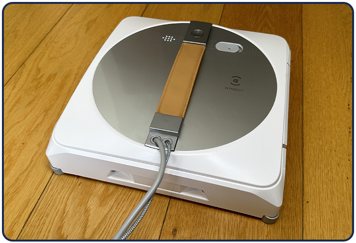 L'Ecovacs Winbot W1 Pro offre un desgin simple blanc et gris argentique avec une poignée en cuir marron